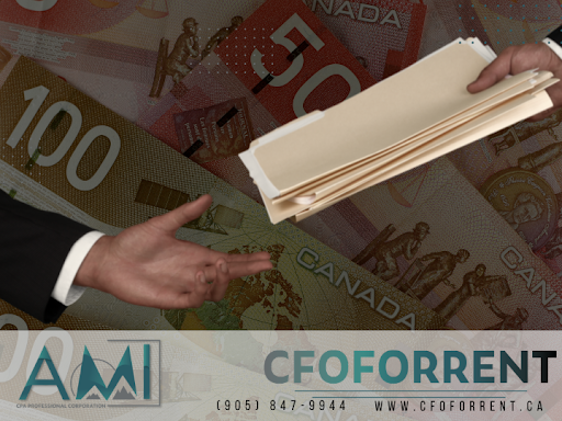 Client of A.M.I. CPA Professional Corporation handing a stack of files over to start a business process review with faded Canadian one hundred and fift dollar bills in the background.