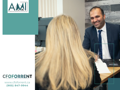 Ahmad Amaduddin, CPA, CA, Managing Partner at A.M.I. CPA Professional Corporation is sitting across from a client whom he is helping to prepare taxes for her business.