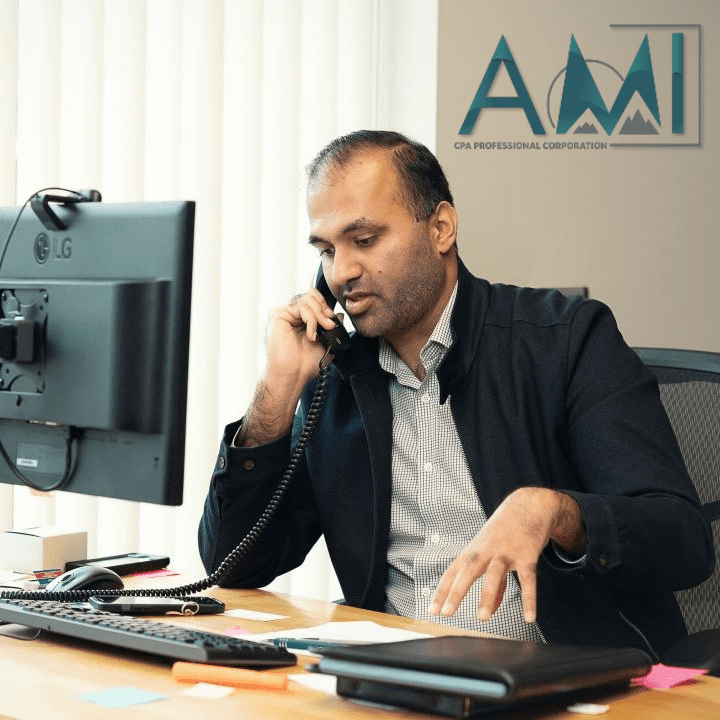 Ahmad from A.M.I. CPA Professional Corporation discussing corporate tax tips on the phone with a client in his Oakville office.