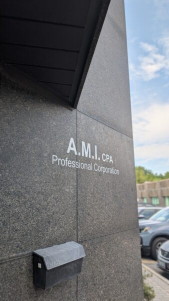A.M.I. CPA Professional Corporation in white writing above a mailbox on an accounting office building in Oakville.