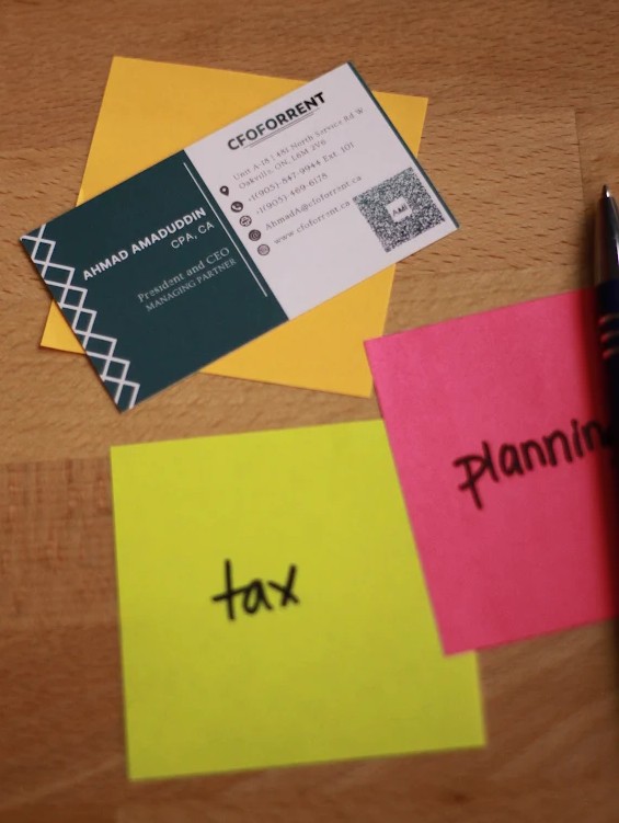 A.M.I. Business card and pen on desk with post it notes